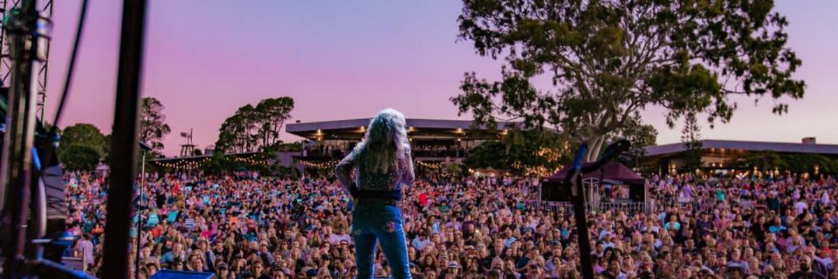 Photo of an artist on stage in front of a big crowd at Sandstone Point Hotel.