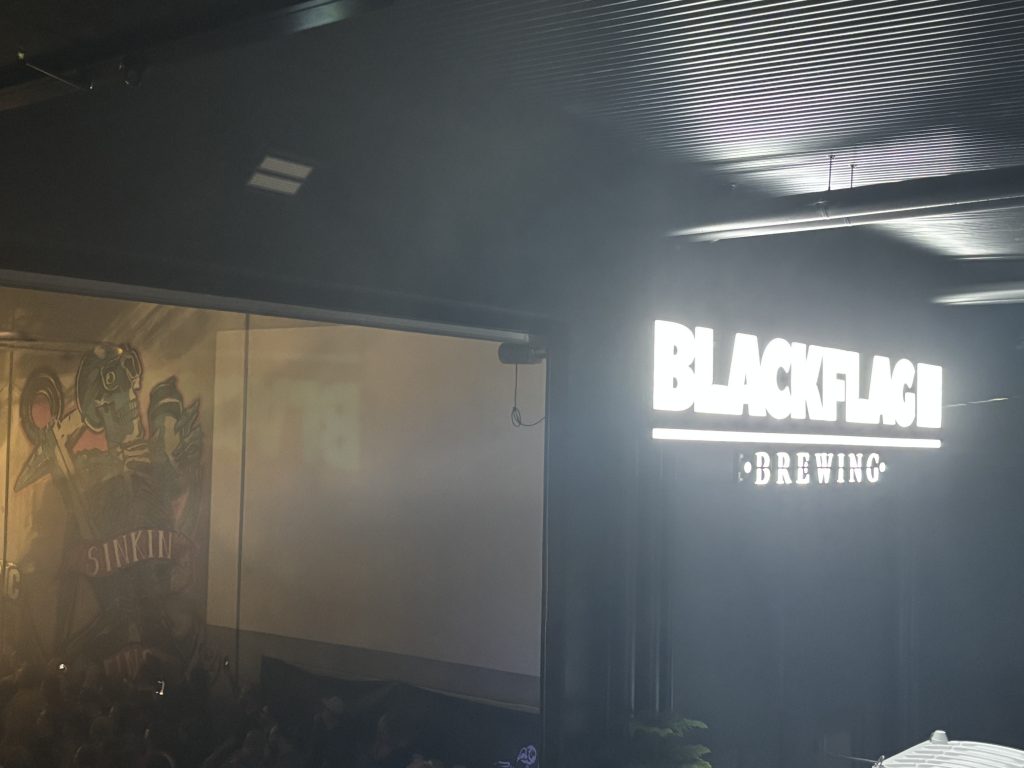 A photo of the front illuminated Blackflag Brewing sign.