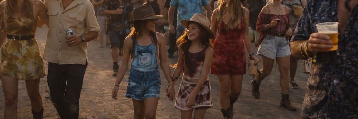 Two young festival-goers holding hands