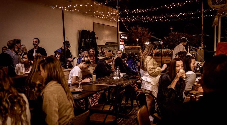 People sitting outside at Alley Cat Espresso in the evening.