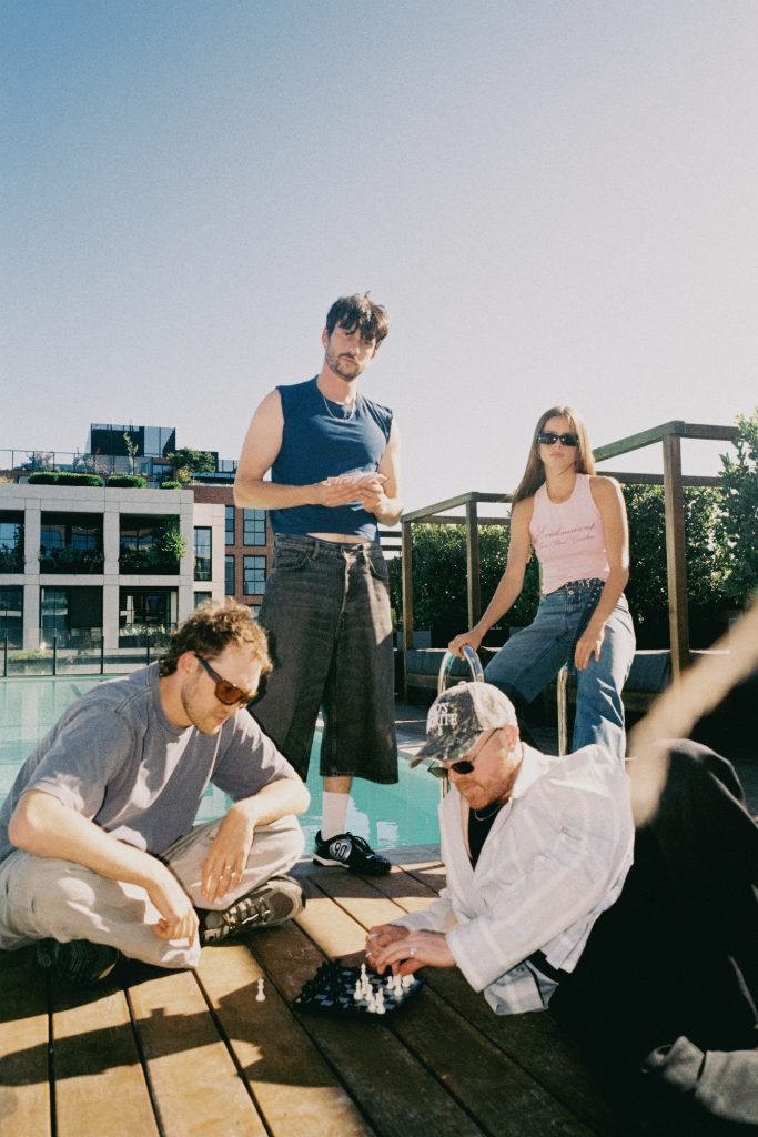 The Jungle Giants hanging beside a pool playing chess.