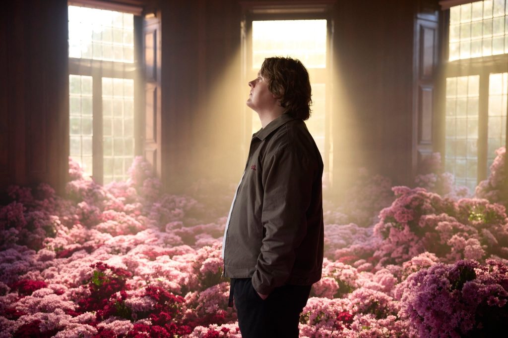Lewis Capaldi standing with pink flowers