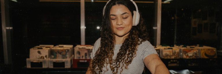 Image of woman with headphones in a record store with words "Brisbane record stores"
