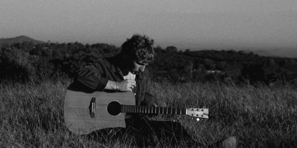 Che Burns with acoustic guitar on the Sunshine Coast