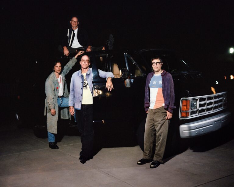 Weezer band members beside a van